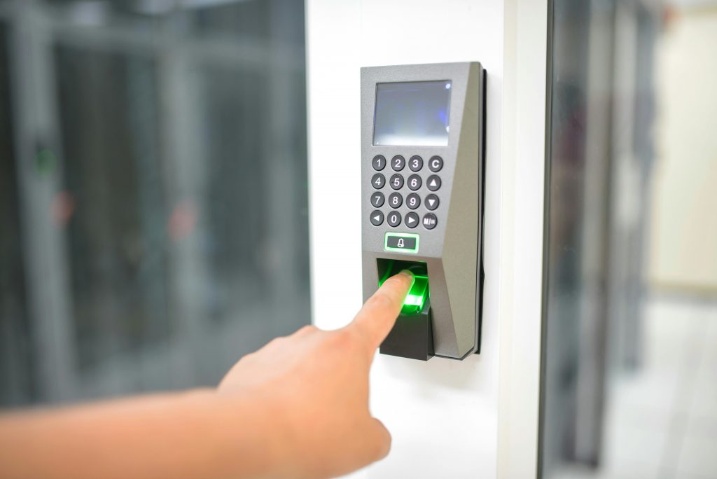 user placing a finger on a fingerprint reader for door access